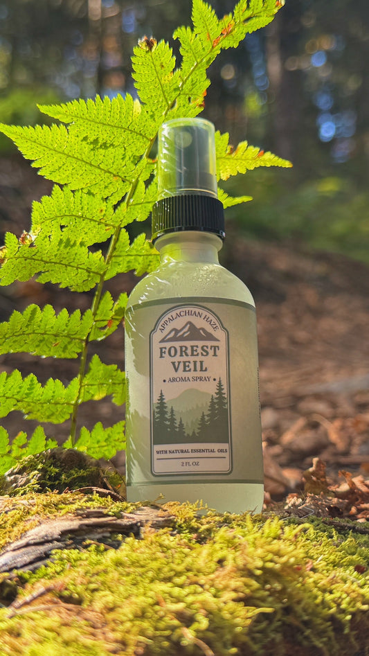 Bottle of 'Forest Veil' on a forest floor with ferns and trees in the background